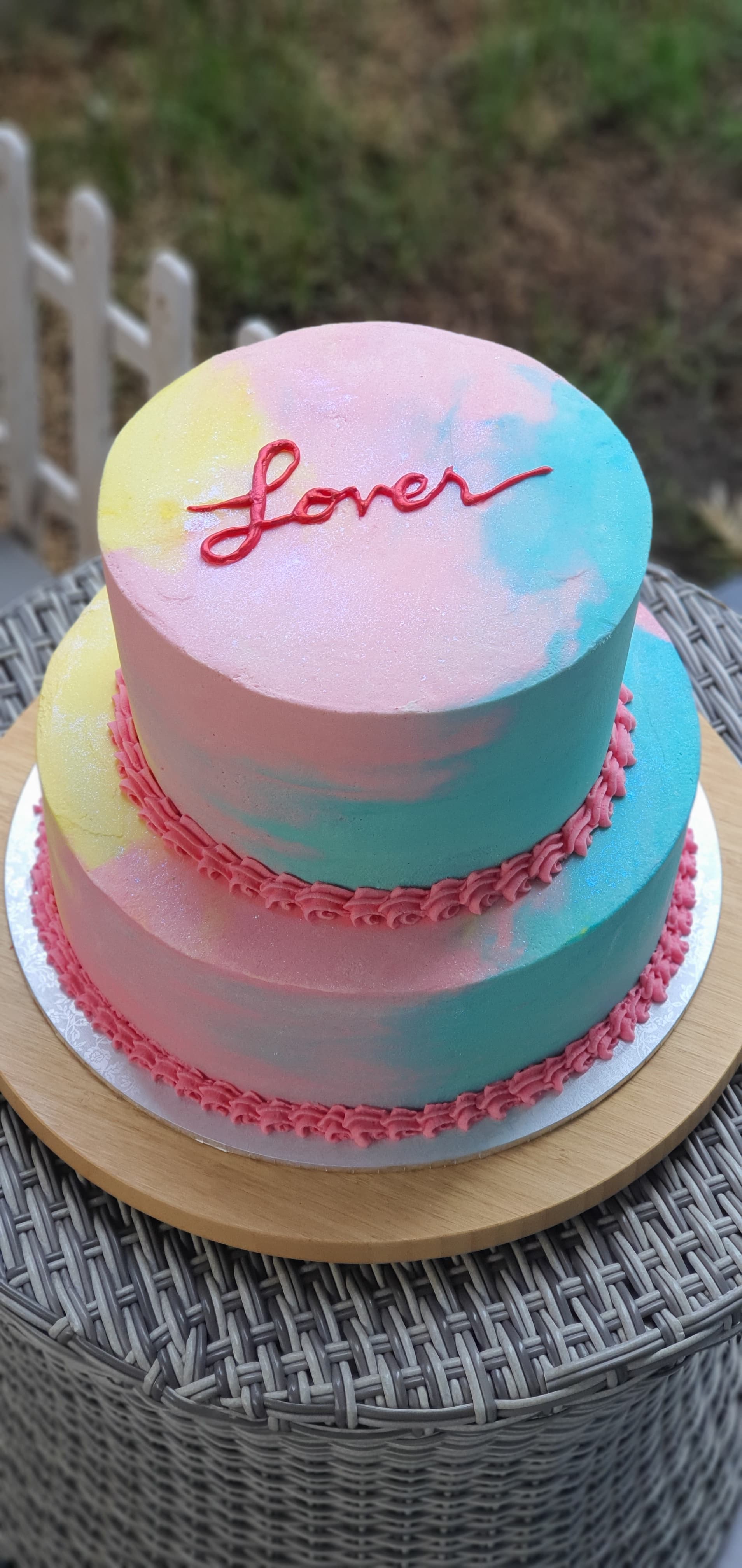 Tarta de dos pisos con efecto acuarela pastel y la palabra Lover en rojo